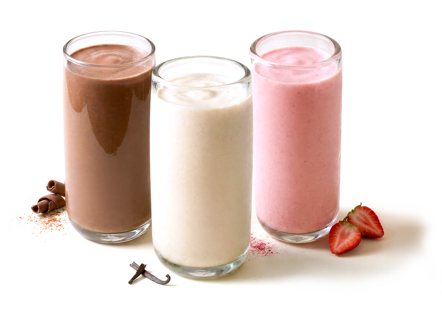 Tall clear glasses filled with Shakeology in different flavors
